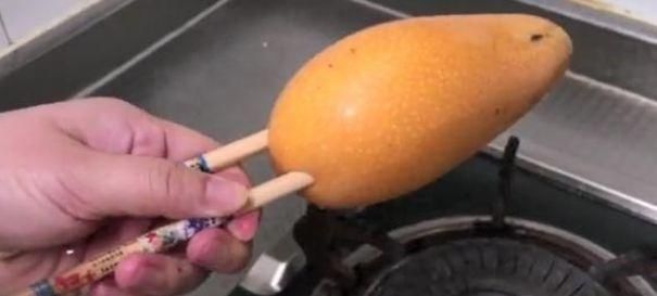  芒果|女子拿芒果在火上烤，又用刀划了两下，这操作结果神了